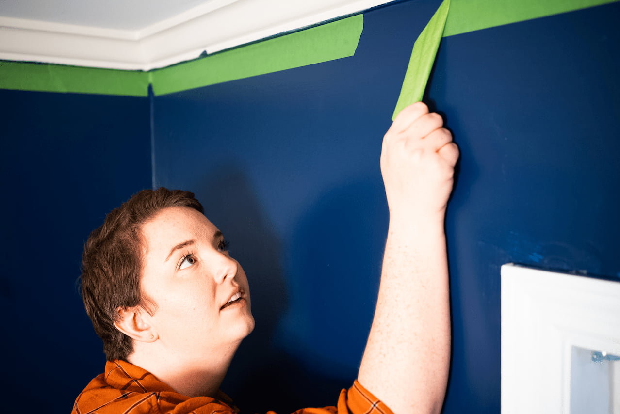 Can painter's tape be left on too long? Yes  - in this picture we see Catherine Ballard pulling green painter's tape off the wall.
